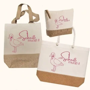 Premium-Taschen-Kollektion von werktraum33 mit kackender Möwe und Spruch „an Scheiß muaß i“, bestehend aus Shopper, Strandtasche und Kulturtasche aus Canvas und Jute.