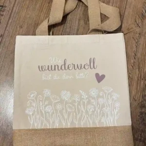 Premium Einkaufstasche aus Canvas und Jute auf Holzboden mit Spruch "Wie wundervoll bist du denn?" | werktraum33