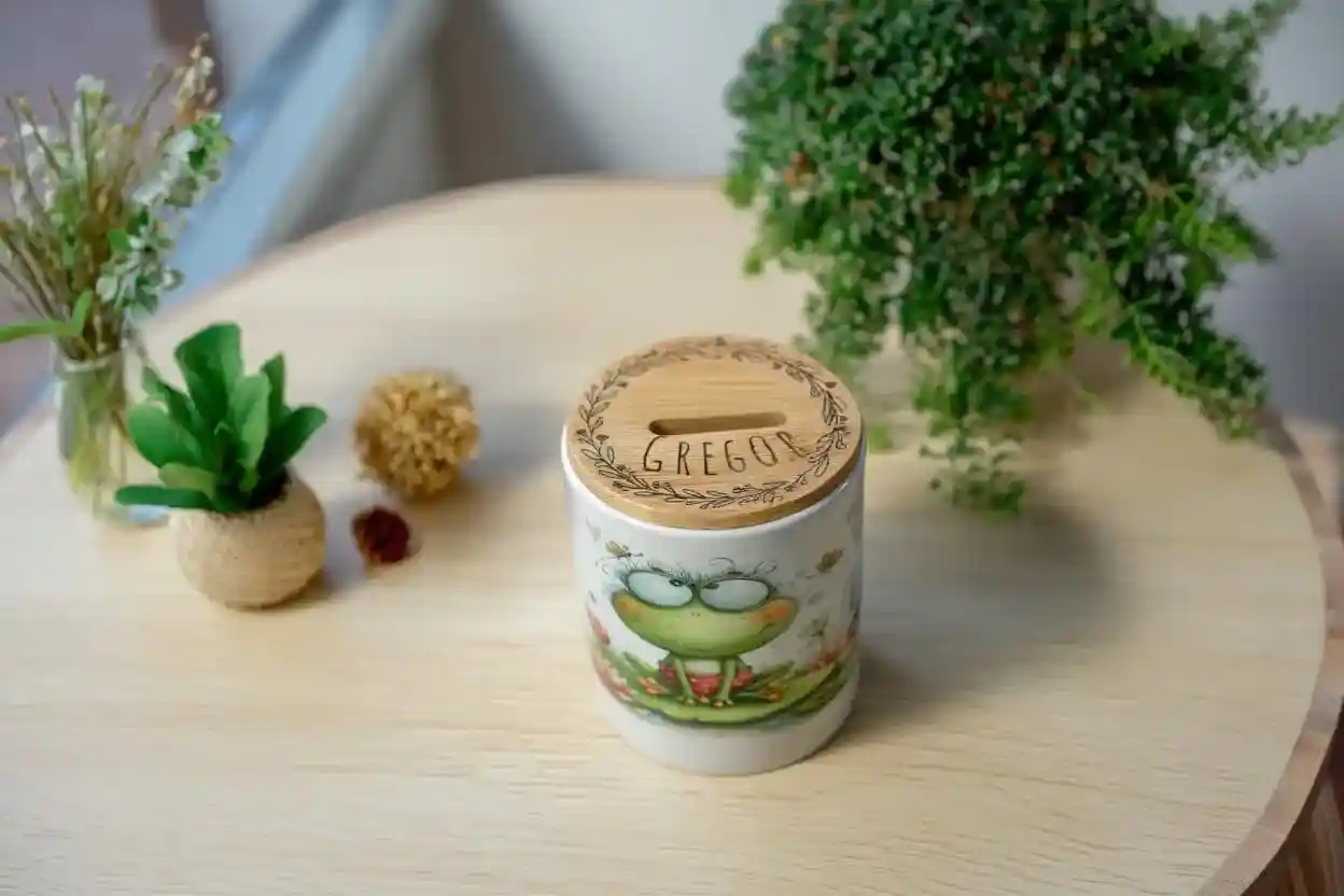 Spardose aus Keramik mit Frosch-Motiv ‚Ein paar Kröten‘ und individueller Namensgravur auf dem Bambusdeckel von werk(t)raum33.