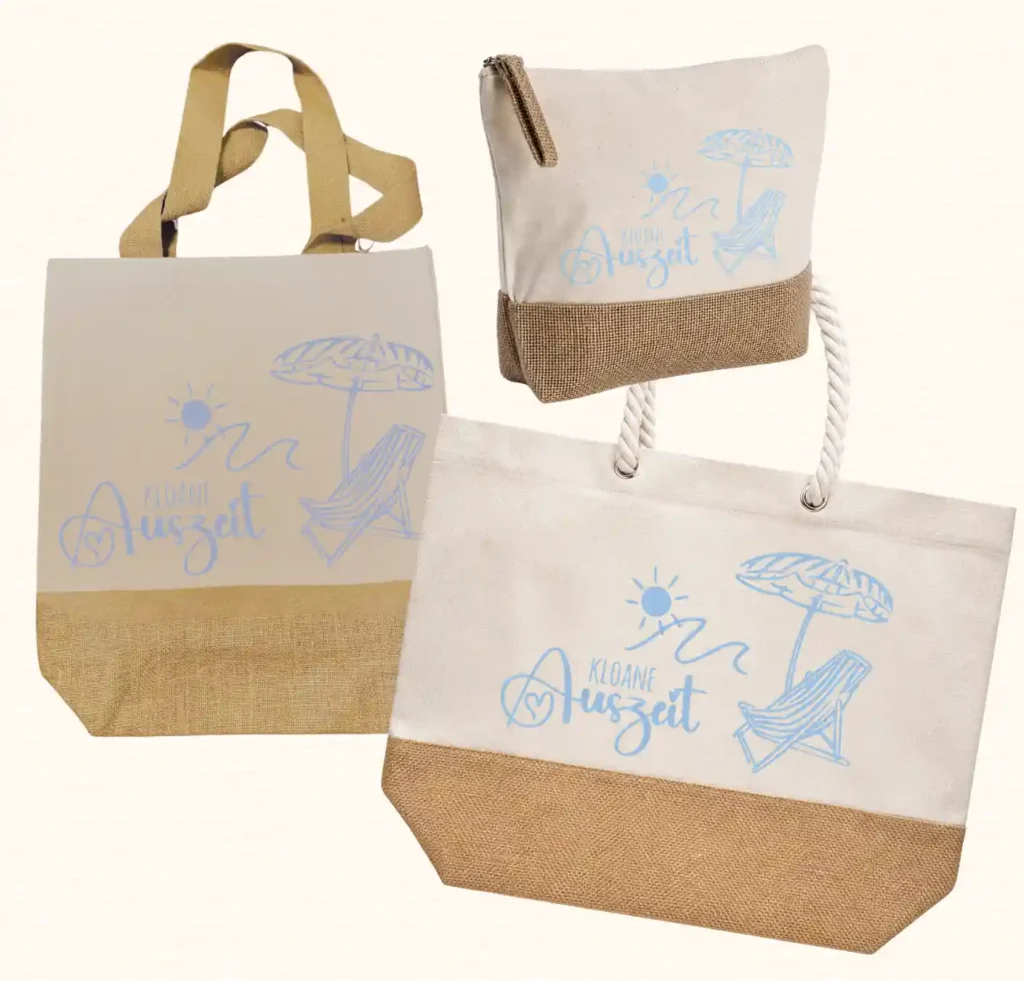 Premium-Taschen-Kollektion von werktraum33 mit Spruch „KLOANE Auszeit“, bestehend aus Shopper, Strandtasche und Kulturtasche aus Canvas und Jute.